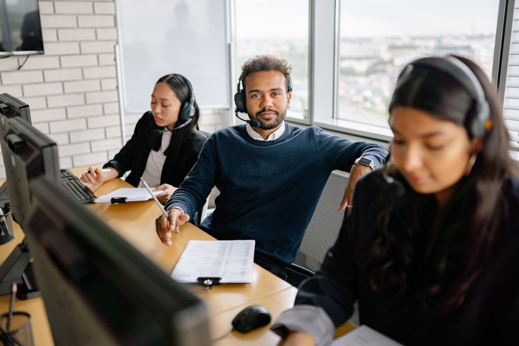 A focused call center team attending customer calls in a modern office setting.
